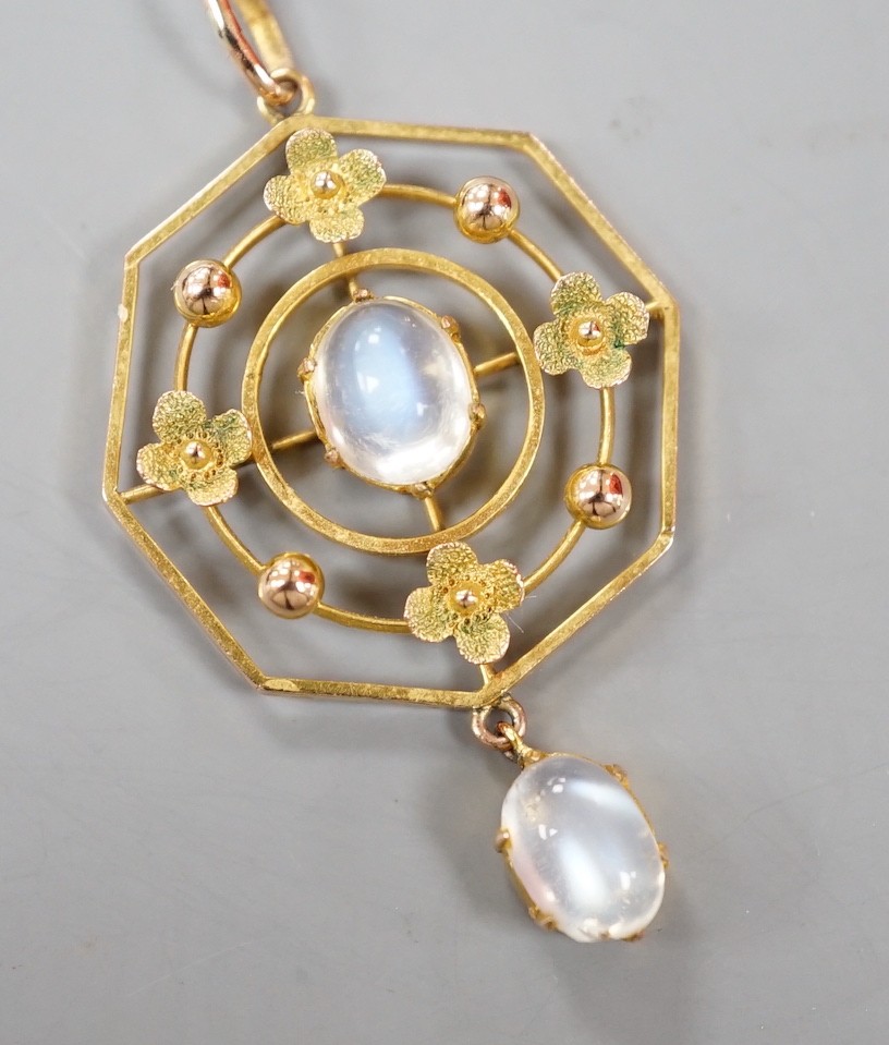 An Edwardian yellow metal and two stone oval cabochon moonstone set open work octagonal drop pendant, 0verall 42mm, gross weight 2.5 grams.